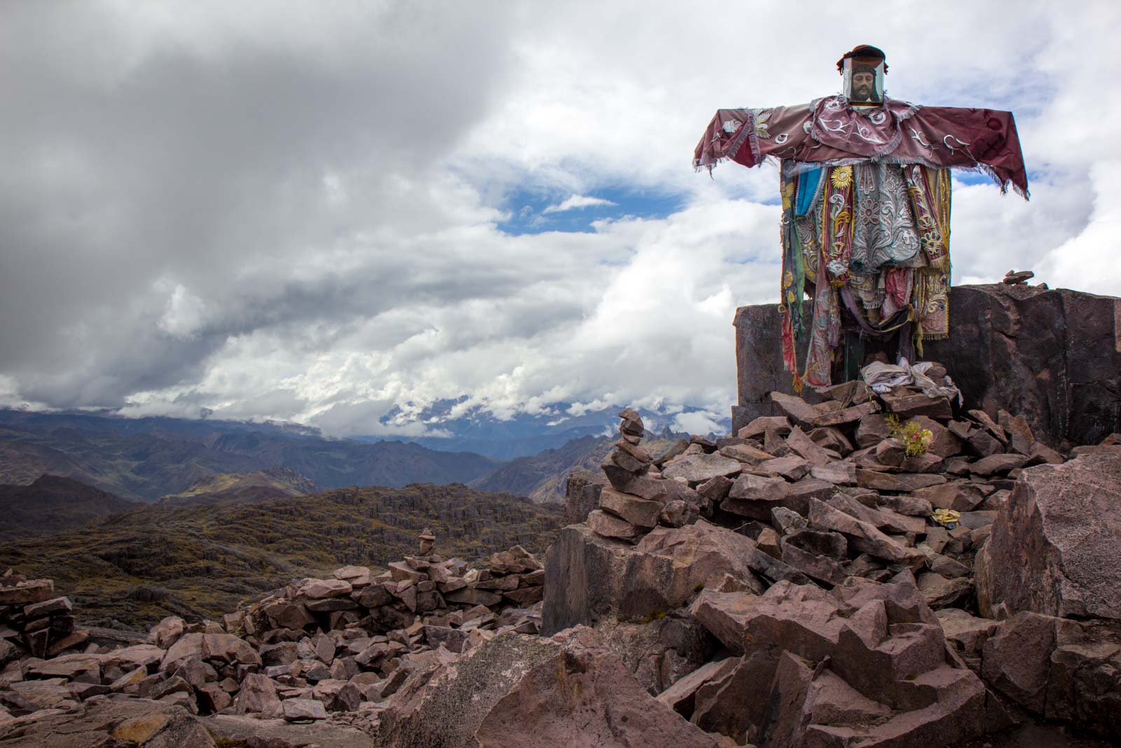 Image of the statue of Jesus at the peak of the Lares Trek covered in rags and bandanas